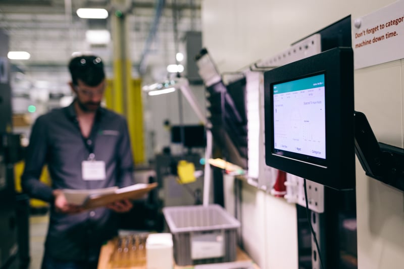 Man Standing at Tablet on Shop Floor.
