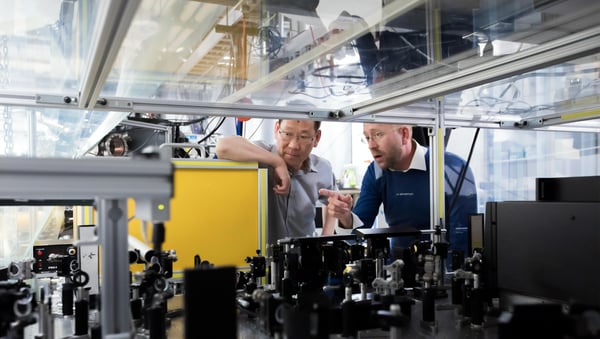 Man Pointing to Train Another in Industrial Setting