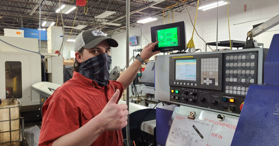 Operator Gives a Thumbs Up at a CNC Machine.